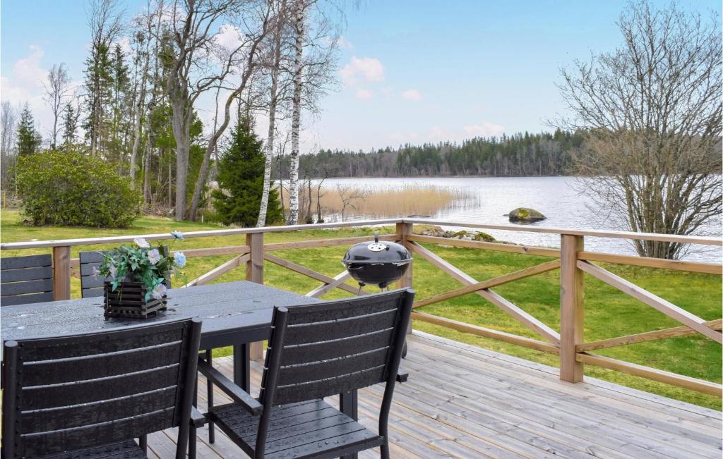 una mesa y sillas en una terraza de madera con vistas al lago en Cozy Home In Nssj With House Sea View en Nässjö
