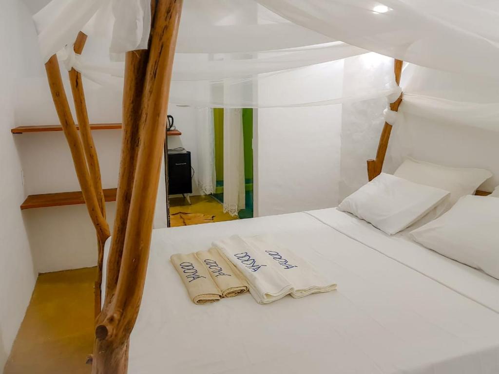 ein Bett in einem Zimmer mit zwei Kissen darauf in der Unterkunft Odoya Morro de São Paulo in Morro de São Paulo