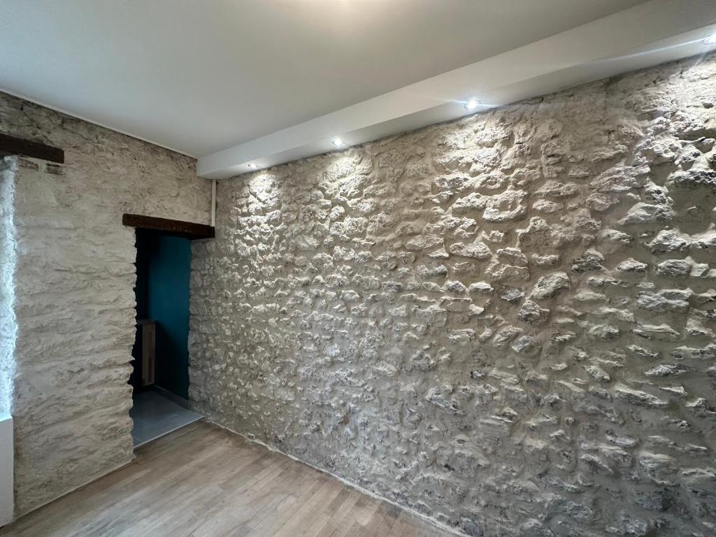 a stone wall in a room with a blue door at Appartement calme design et Comfort in Orléans