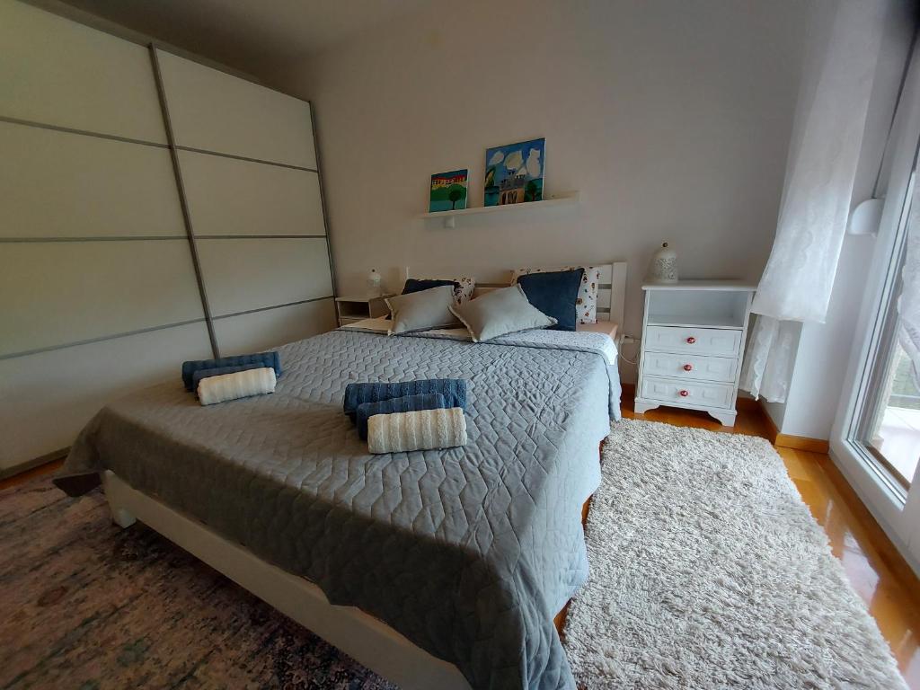 a bedroom with a large bed with blue pillows at Apartman Doboga in Ozalj