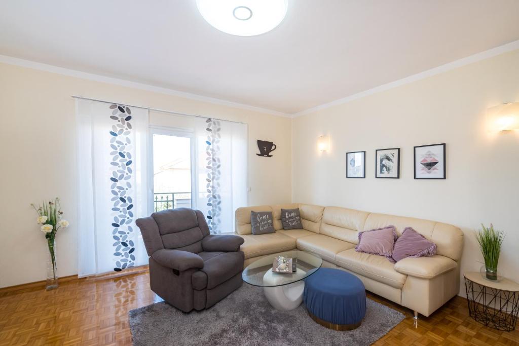 ein Wohnzimmer mit einem Sofa und einem Stuhl in der Unterkunft Apartment Višnja in Zadar