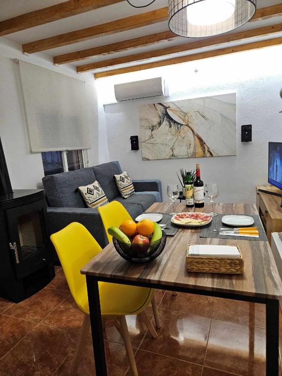 a living room with a table and yellow chairs at El Rincón de Mariela By Travel Home in Segura de la Sierra