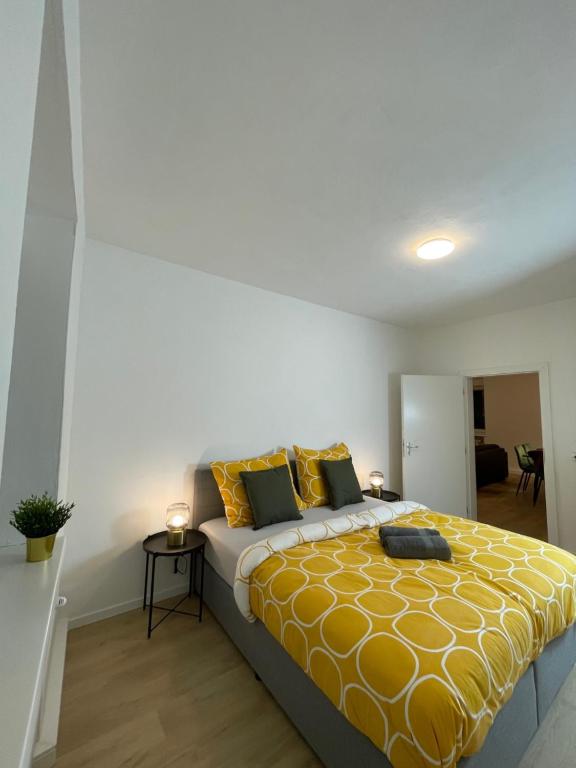 a bedroom with a large bed with a yellow blanket at GROSS - REAL ESTATE in Leoben