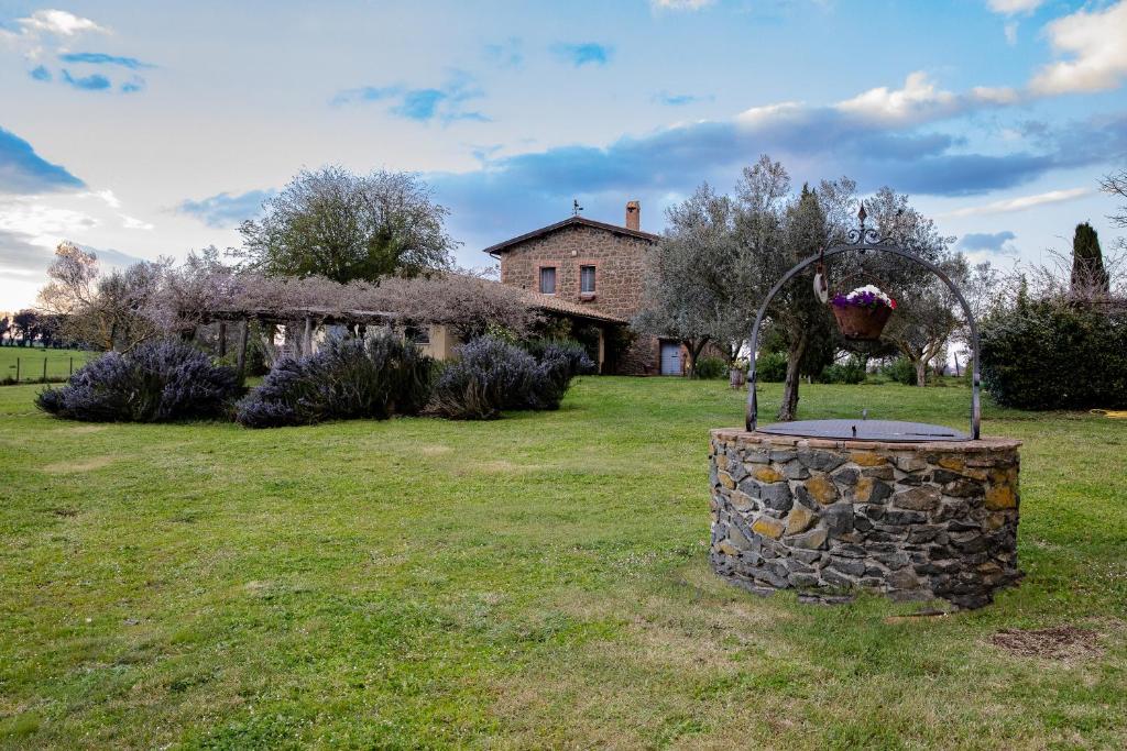 a garden with a fountain in front of a house at Casale del Rosmarino - Suite Albicocca in Montefiascone