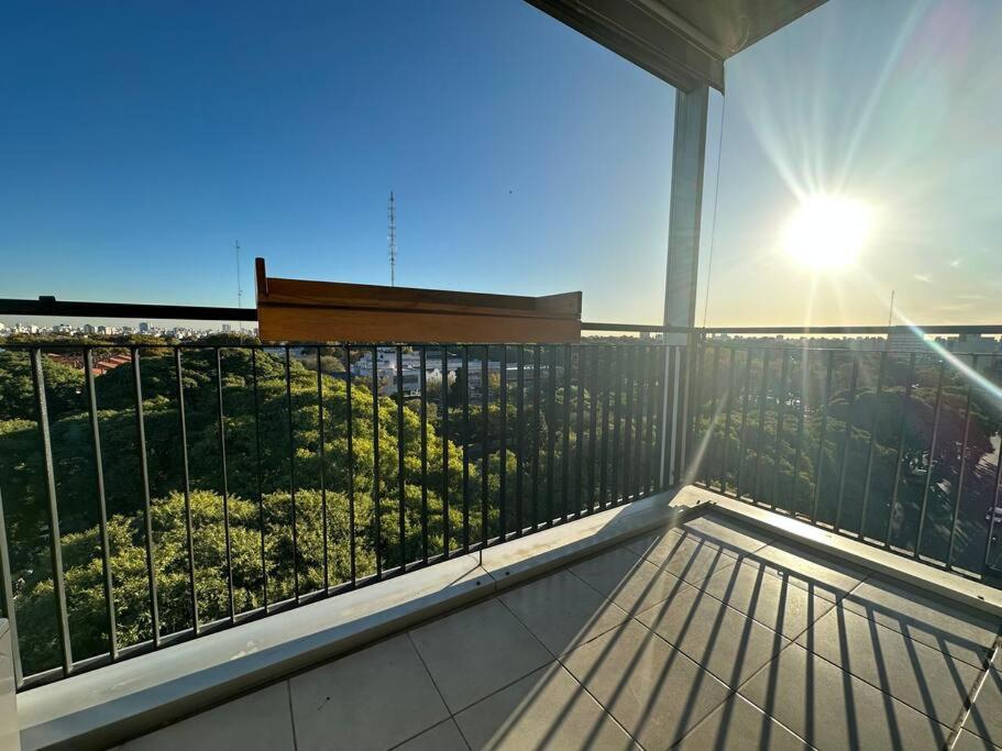 a balcony with the sun shining through a window at Chacarita Sunset l Andes Park in Buenos Aires