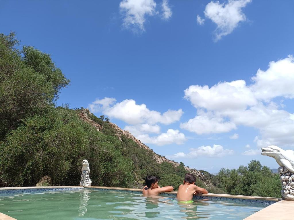 dos chicos en una piscina con una montaña en el fondo en villaluna, en Tánger