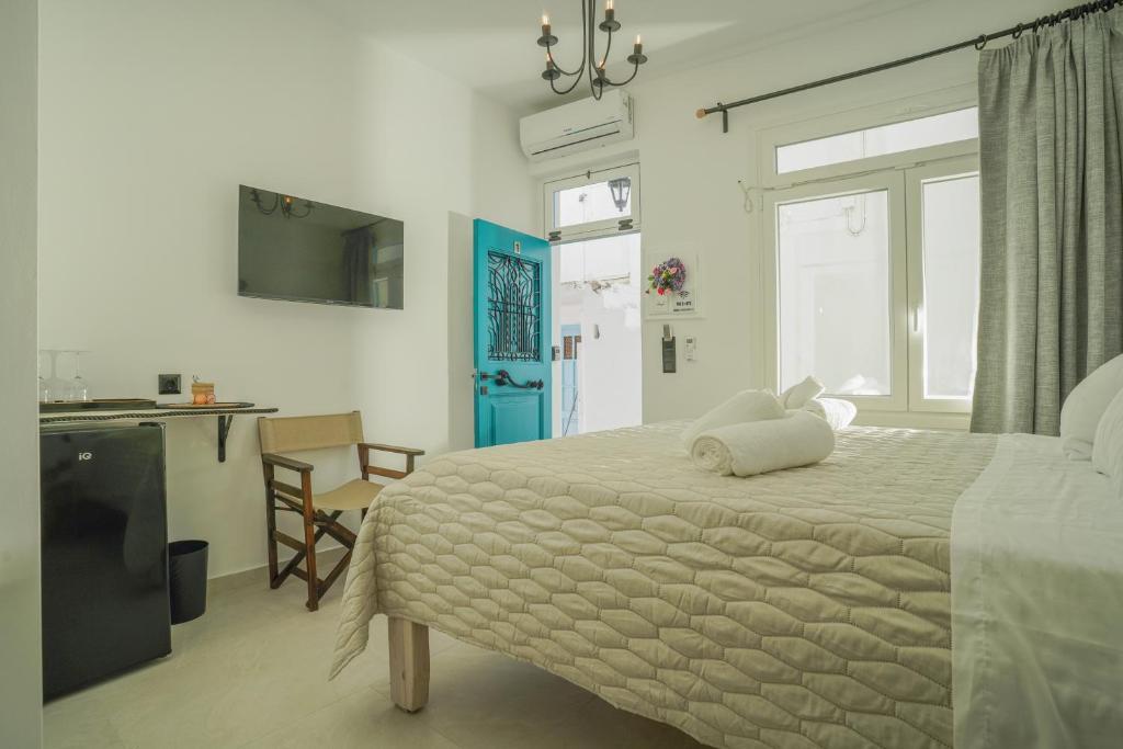 a bedroom with a large bed and a kitchen at Seabed Suites Mykonos in Mikonos