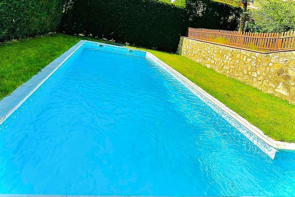 a swimming pool with blue water in a yard at Villa Arboleda in La Losa
