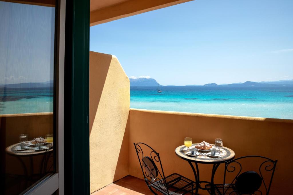 a balcony with two tables and a view of the ocean at Hotel Castello in Golfo Aranci