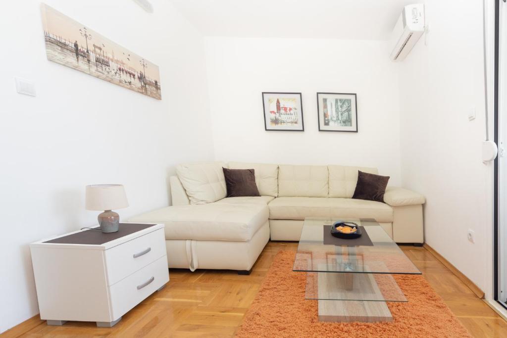 a white living room with a white couch and a table at Apartments Horizont in Budva