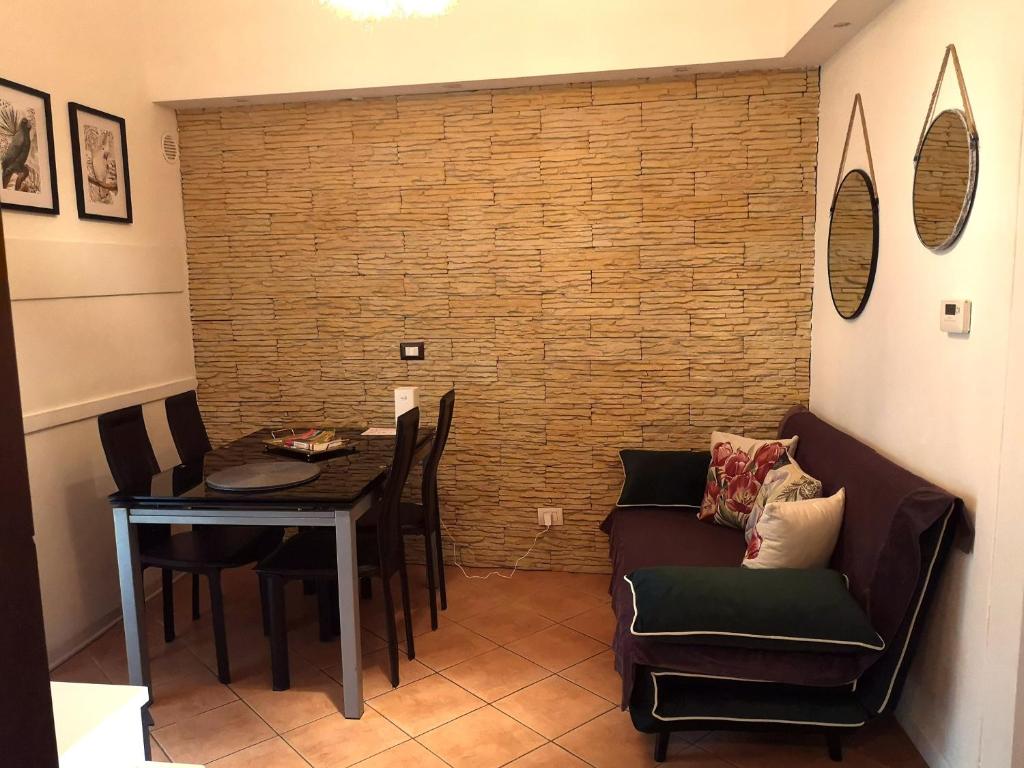 ein Wohnzimmer mit einem Tisch, einem Sofa und einem Stuhl in der Unterkunft Casa Ludo in Lucca