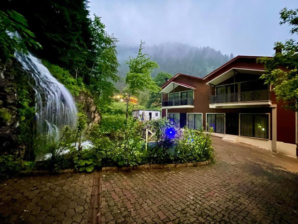 a house with a garden in front of a building at Uzungöl Bungalow in Uzungol
