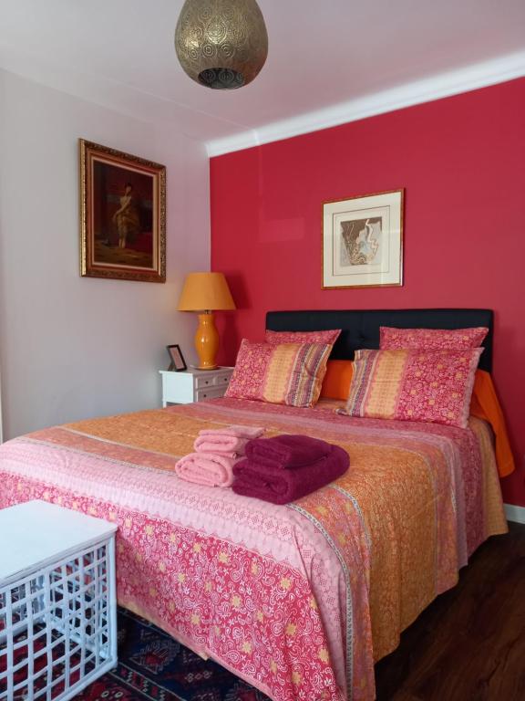 1 dormitorio con 1 cama con pared de color rosa en La Maison de Soso, en Chambon-le-Château