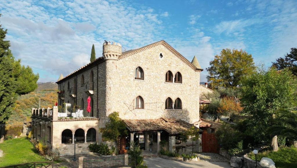 um antigo edifício de pedra com uma torre no topo em Hotel Lo Smeraldo em Roccavivara