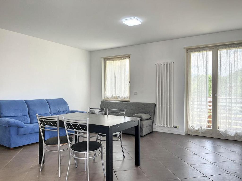ein Wohnzimmer mit einem Tisch und einem blauen Sofa in der Unterkunft Villa Eden a Levico Terme in Levico Terme