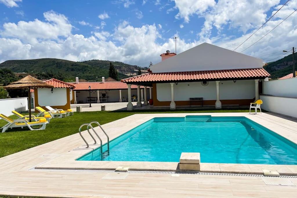 a swimming pool in front of a house at Sitio Terra do Loureiro in Porto de Mós