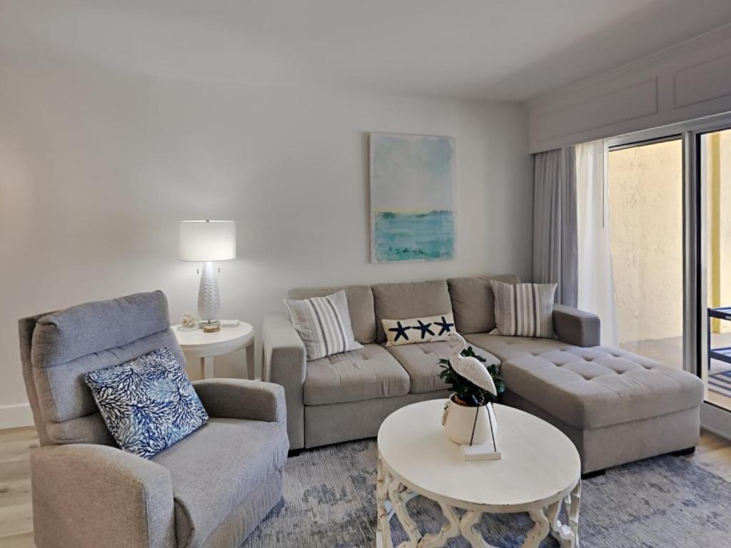 a living room with a couch and a table at Driftwood Towers #1F - Palm View in Gulf Shores
