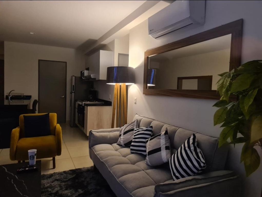 Departamento con vista increíble en piso 16 في غواذالاخارا: غرفة معيشة مع أريكة ومرآة