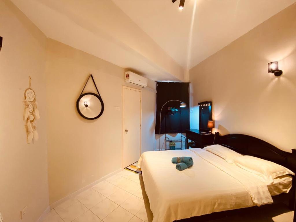 um quarto com uma cama e um relógio na parede em Cozy Apartment - Sri Lagenda Resort Langkawi em Kuah