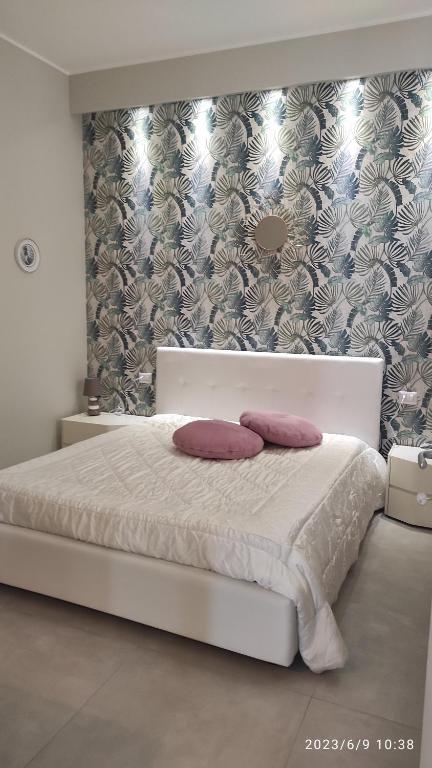 普利亞區格拉維納的住宿－Grazia Guest House，卧室配有白色的床和两个枕头