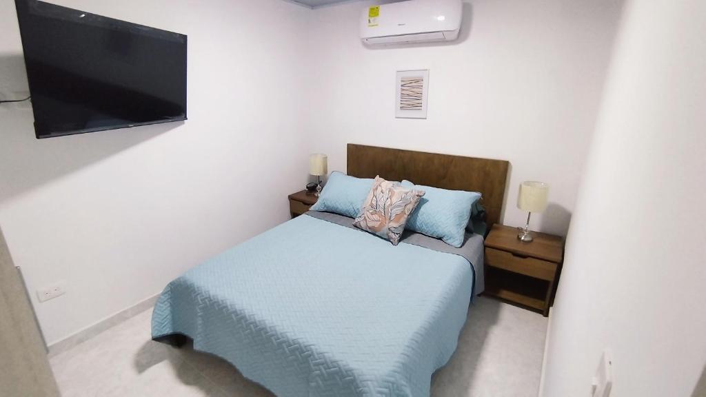 um quarto com uma cama e uma televisão de ecrã plano em Edificio GrandSky em Cali