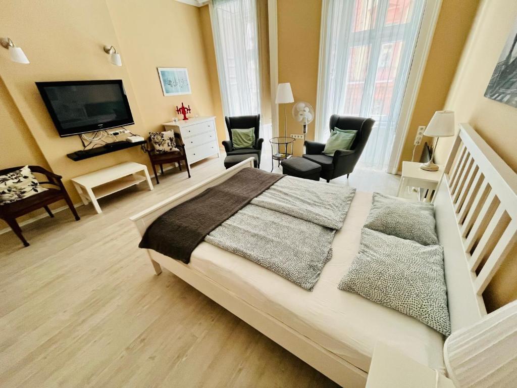 a bedroom with a large white bed and a television at Academy Home - Elegant place next to the Parliament in Budapest