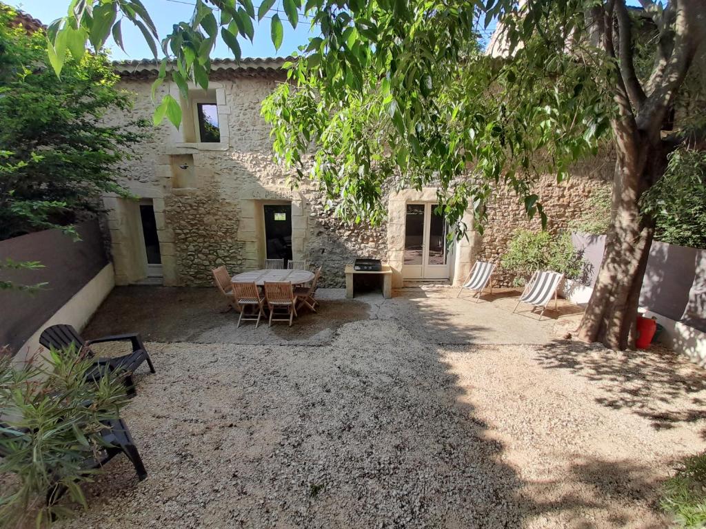 a patio with a table and chairs in front of a building at Gite Esprit Colibri in Pont-Saint-Esprit