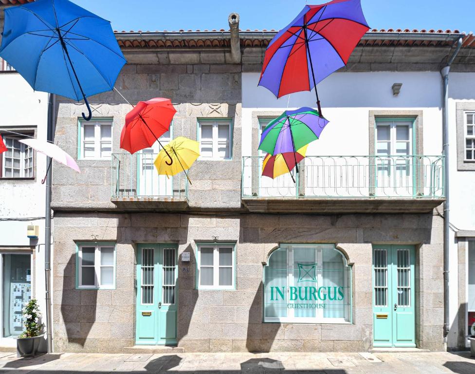 four umbrellas in the air in front of a building at In Burgus guest house in Viana do Castelo