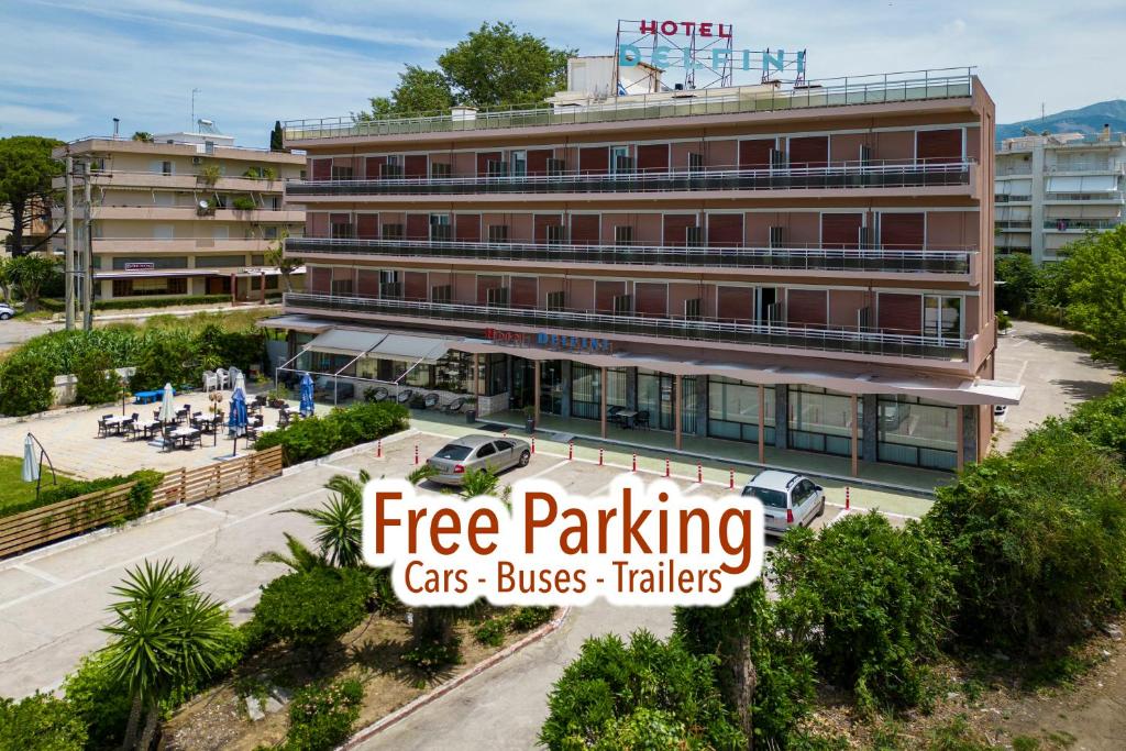 a building with a sign that reads free parking cars buses talks at Delfini Hotel in Patra