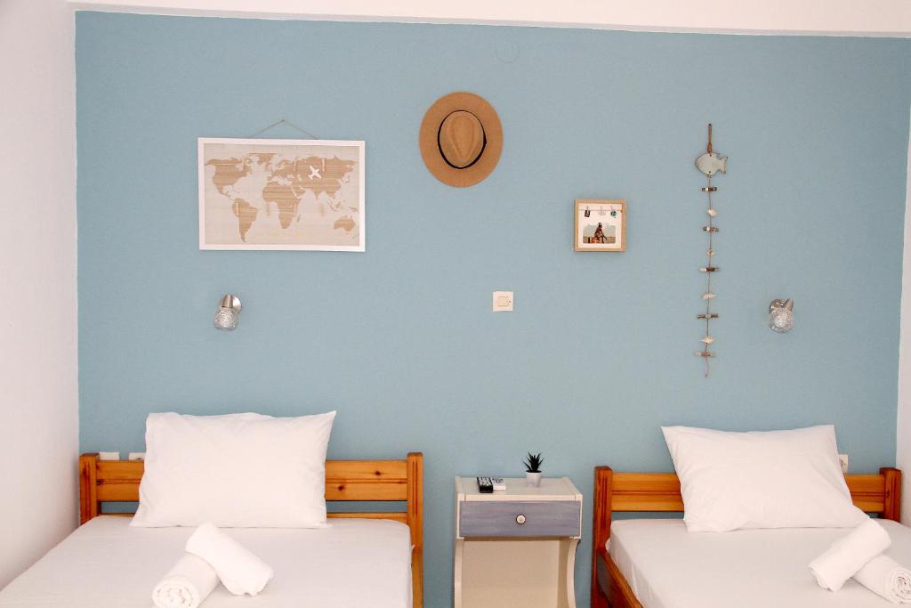 2 camas en una habitación con una pared azul en Lemonia, en Paralia Katerinis