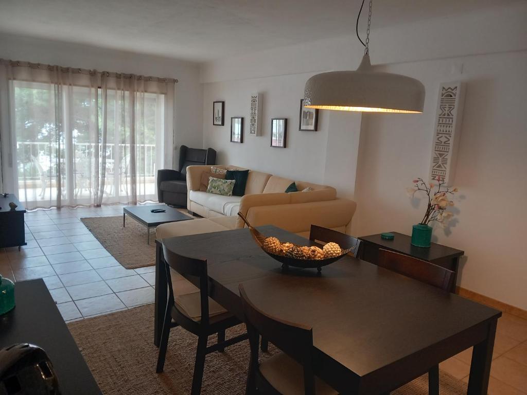 una sala de estar con una mesa y un sofá en Apartamento Amarelinha, en Lagos