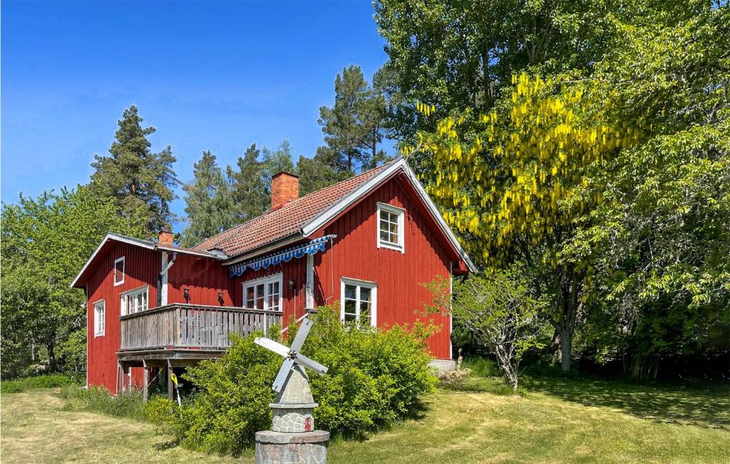 ein rotes Haus mit einer Windmühle davor in der Unterkunft Stunning Home In Ydre With Kitchen 
