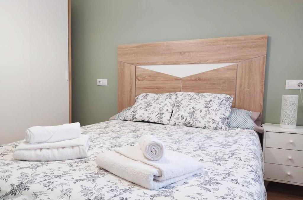 ein Schlafzimmer mit einem Bett mit Handtüchern darauf in der Unterkunft COQUETO APARTAMENTO EN OVIEDO in Oviedo