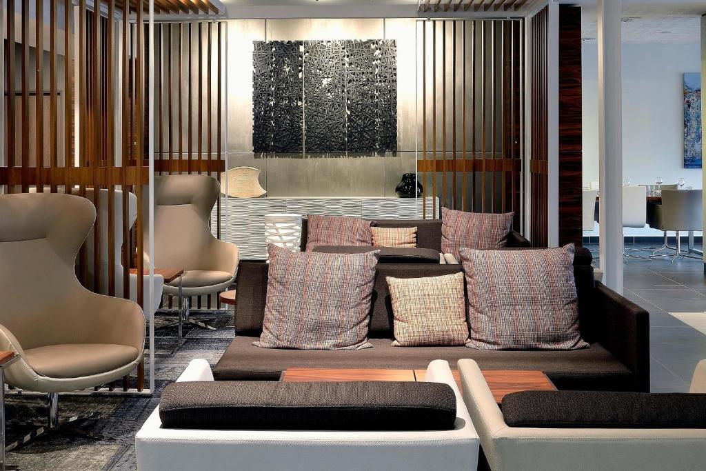 a waiting room with pillows and a couch and chairs at AC Hotel by Marriott Marseille Prado Vélodrome in Marseille