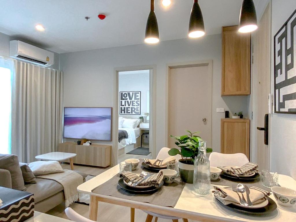 sala de estar con mesa y sala de estar en Srinakarin Lasalle 2 BR Bangkok, en Bangna