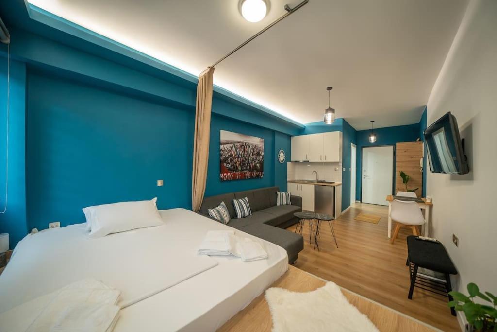 una camera da letto con un grande letto bianco e una parete blu di Kozani Residence 1 a Kozani