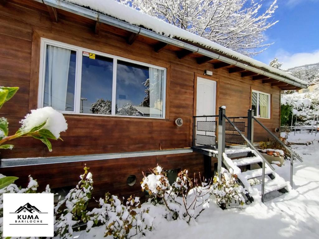 Cabaña de madera en la nieve con porche en Cabaña en Barrio Melipal Bariloche en San Carlos de Bariloche