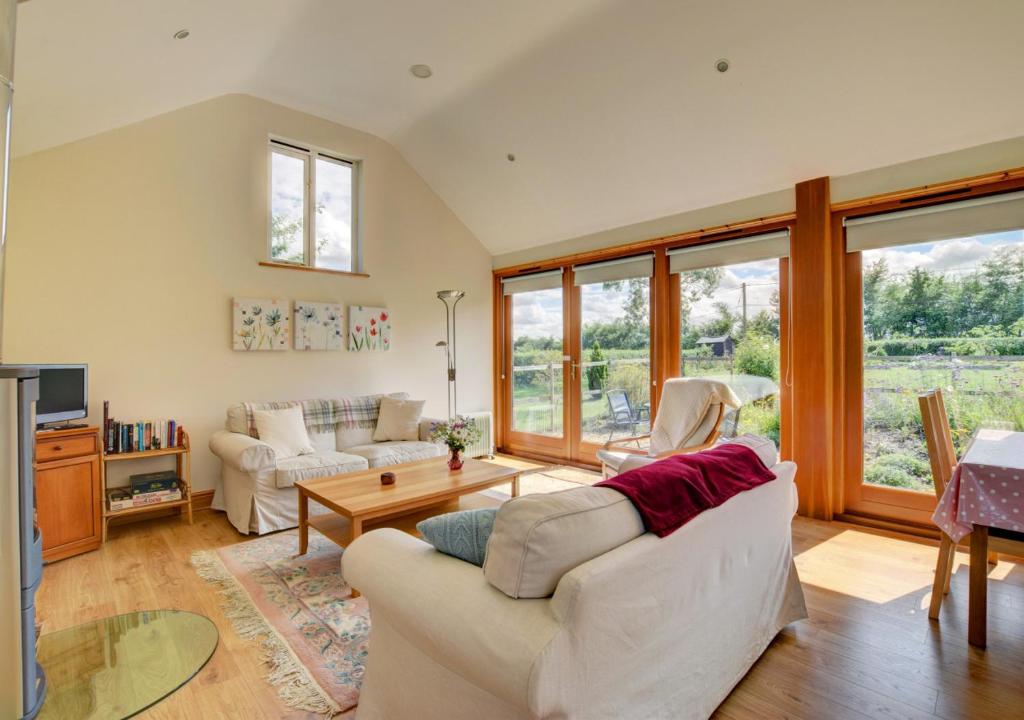 a living room with a couch and a table at Akenfield Cottage, Letheringham in Kettleburgh