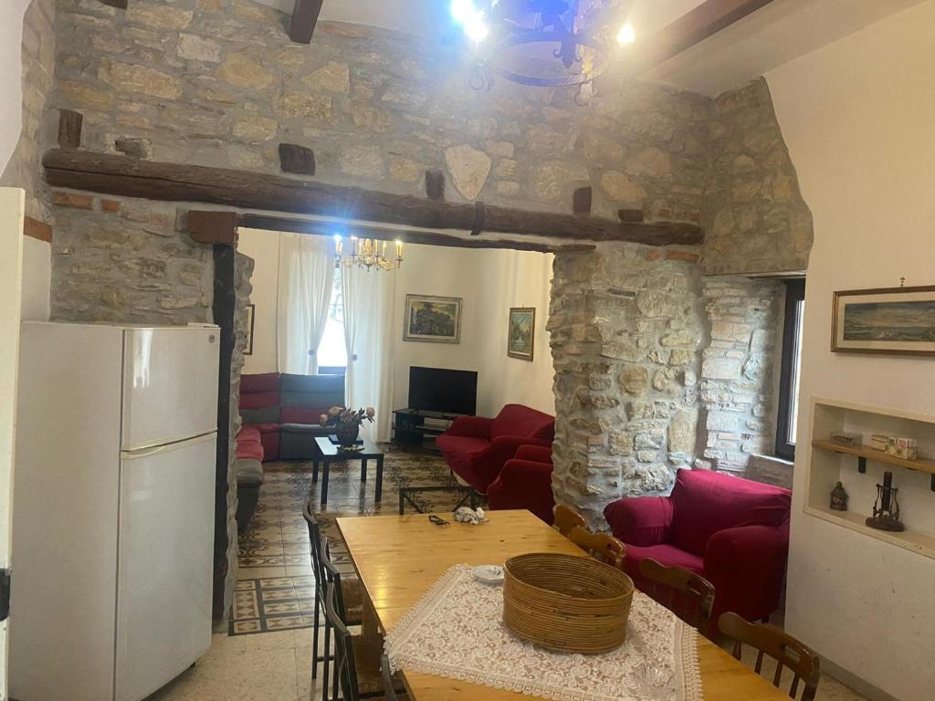 uma sala de estar com um frigorífico branco e uma parede de pedra em Il Casolare em Cantalupo nel Sannio