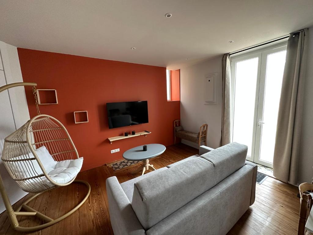 un salon avec un canapé et une télévision dans l'établissement *Le Terracotta* T2 Hyper-Centre, à Roanne