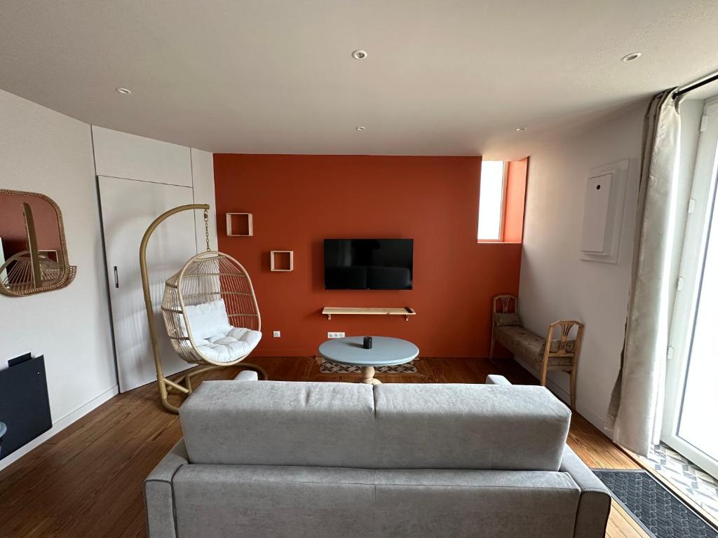 a living room with a couch and a tv at *Le Terracotta* T2 Hyper-Centre in Roanne