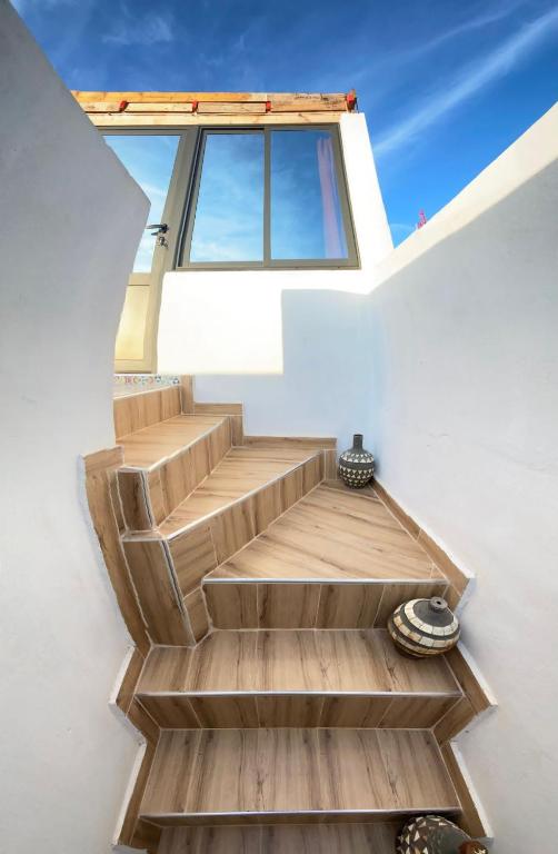 a set of stairs in a house with a window at EL Faro Surfstay in Tamri