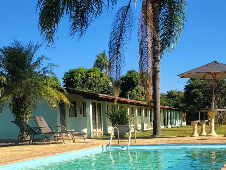 una casa con piscina y palmeras en Pousada Rancho Caipira, en Socorro