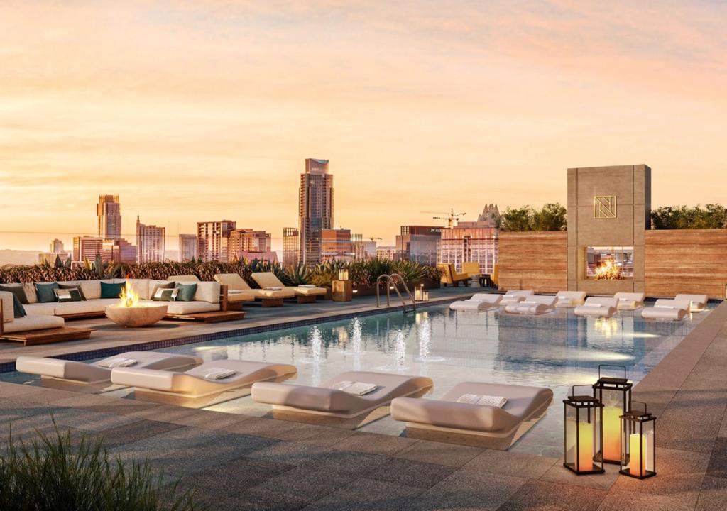 una piscina con tumbonas y vistas al perfil urbano en Brand New Rainey Street Condo with City and Lake View, en Austin