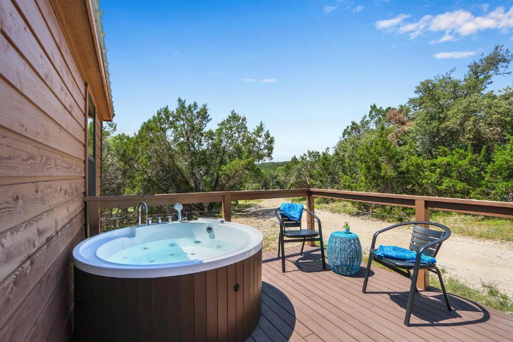 a hot tub on a deck with two chairs at Terlingua at the Bend in Wimberley