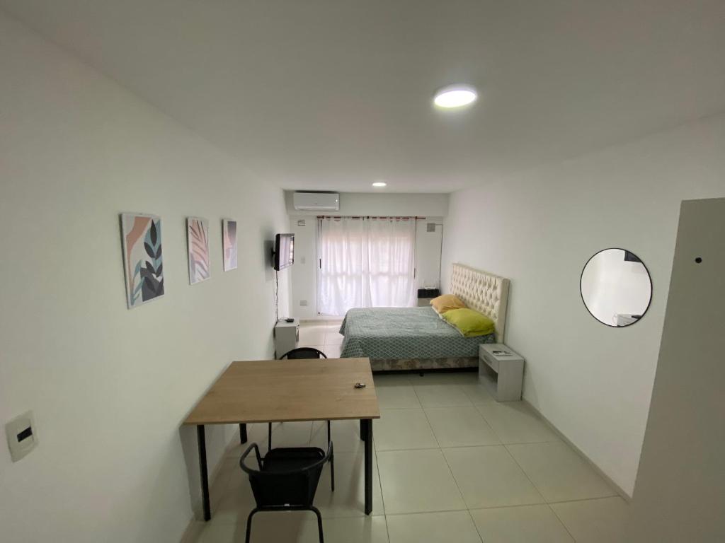 a bedroom with a bed and a table in a room at Depto zona centro muy comodo. in Rosario