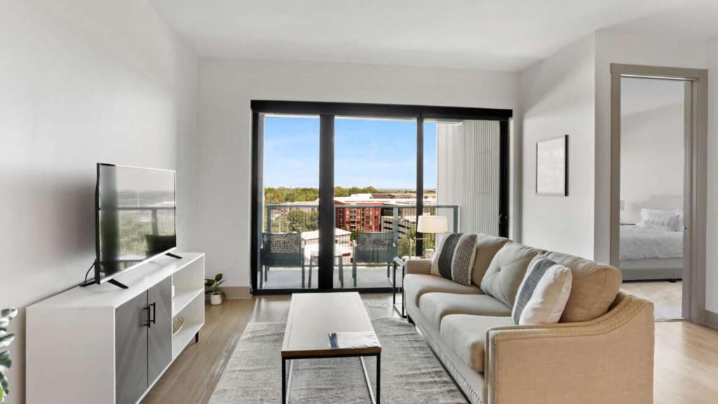 a living room with a couch and a tv at Luxury Apt in West Midtown in Atlanta