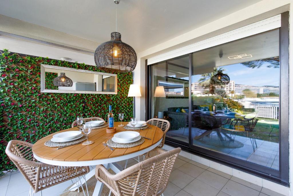 a dining room with a wooden table and chairs at Luxury 3 pièce Garden Apartment in Cannes Marina in Mandelieu-La Napoule
