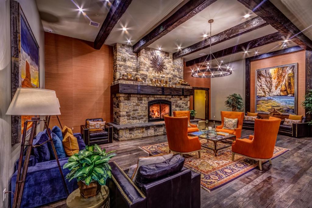 a living room with a stone fireplace and furniture at Desert Rose Resort & Cabins in Bluff