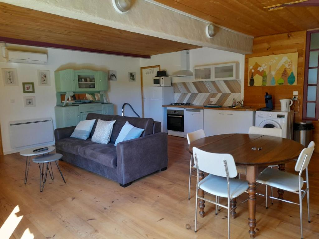 a living room with a couch and a table at Appartement individuel rez de jardin 3 a 5 personnes proche Albi in Cadalen